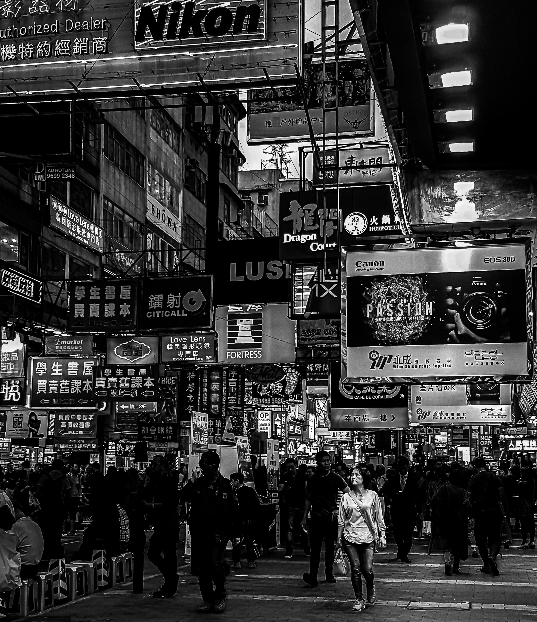 A woman illuminated within a dense city crowd